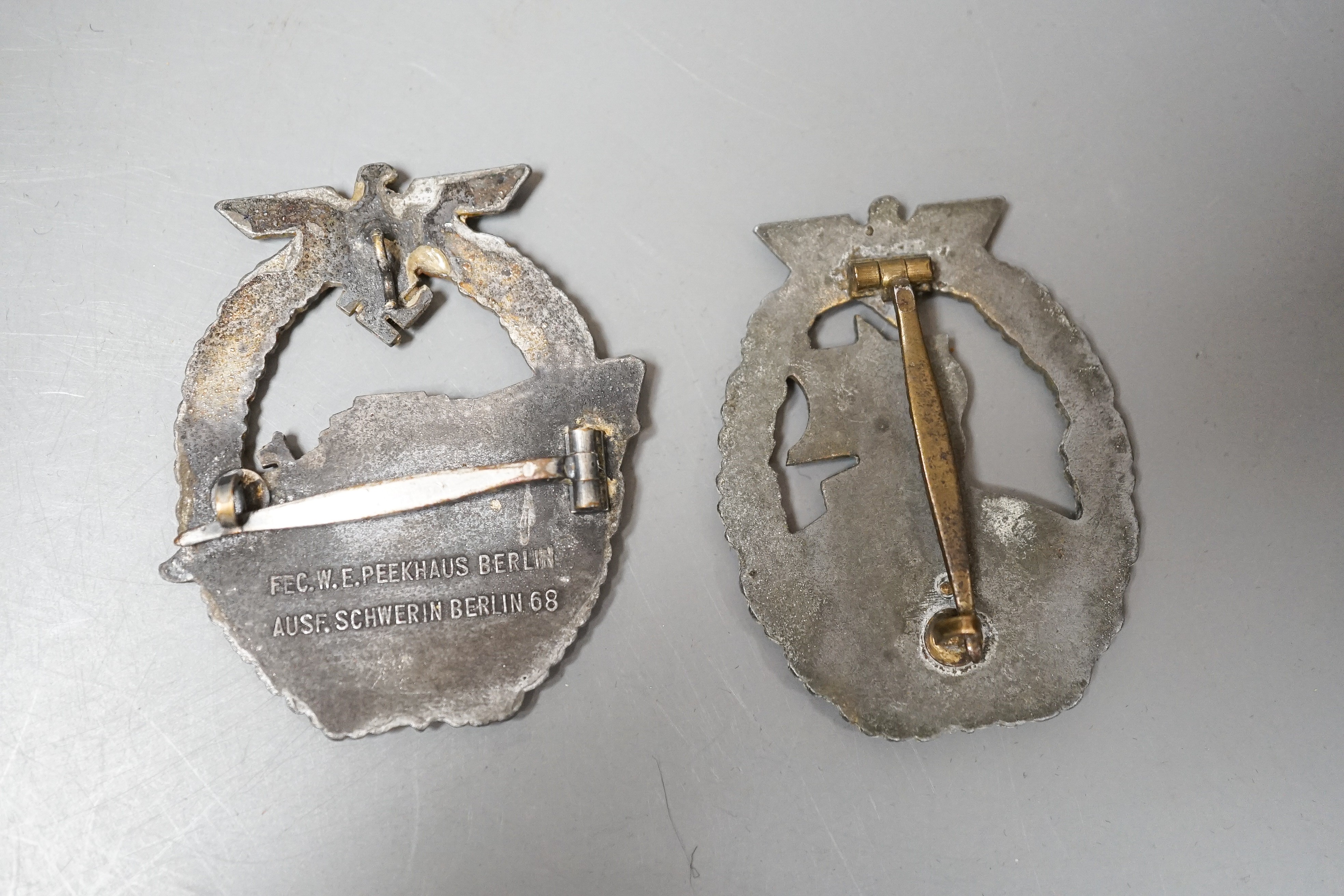 A WW2 German Kriegsmarine E-Boat Badge, marked FEC. W.E. PEEKHAUS BERLIN AUSF. SCWERN BERLIN 68 and an Auxiliary Cruiser War Badge (2)